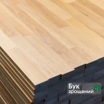 Close-up of a stack of finger-jointed beech furniture panels showing the jointed wood texture.