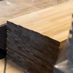 Side perspective of a neat stack of finger-jointed beech panels ready for delivery.