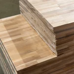 Close-up of the finger joints on the edges of stacked beech wood panels.