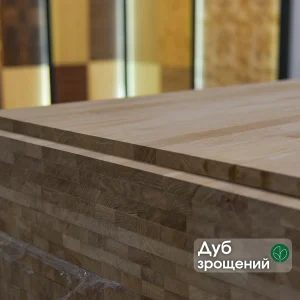 Laminated edge of a finger-jointed oak furniture panel with a text label.