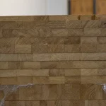 Close-up of the stacked ends of 20mm oak furniture boards showing the precise finger-jointing.