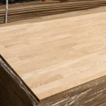 Stack of finished finger-jointed oak furniture boards wrapped in protective plastic.