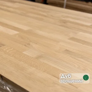 Close-up of a finger-jointed oak furniture board with a text overlay indicating the wood species.