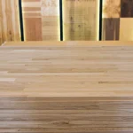 Front view of a stack of finger-jointed oak furniture boards in a showroom.
