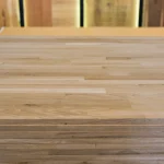 Top-down view of the smooth surface of a finger-jointed oak furniture panel.
