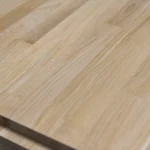 Angled close-up of the sanded surface of a grade 1 finger-jointed oak panel.