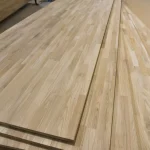 Perspective view of several long finger-jointed oak panels stacked together.