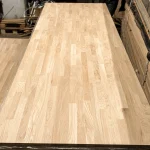 Long finger-jointed oak edge-glued panel laid out on a workshop table.