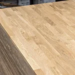 High angle view of a stacked finger-jointed oak furniture panel.