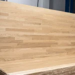 Large finger-jointed oak panel standing vertically in a workshop.