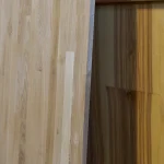Side view of a vertically standing finger-jointed oak panel showing its edge and thickness.