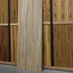 Full-length view of a 3x1 m finger-jointed oak furniture panel standing vertically in a showroom.