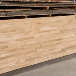 Finger-jointed oak furniture panel standing vertically in a workshop.