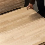 Checking the surface quality of a grade 2 oak panel by hand.