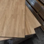 Detailed view of the ends and joints of two stacked oak furniture panels.