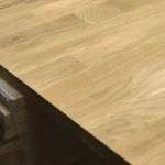Smooth sanded surface and edge of the finger-jointed oak furniture panel.
