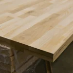 Corner view of a finger-jointed oak panel stacked in a finished goods warehouse.