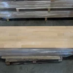 Top view of the Grade 1 alder furniture board resting on a pallet wrapped in protective plastic.