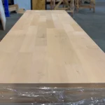 Long perspective view along the length of the 2-meter alder furniture board resting on a pallet.