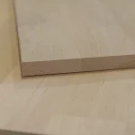 Extreme close-up of the 20mm alder panel's edge profile, showing the dense wood fiber structure.