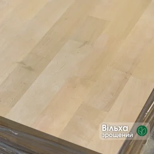 Close-up of the smooth surface of a finger-jointed alder furniture board showing its natural texture and joints.