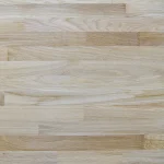 Flat lay texture of a finger-jointed ash furniture panel showing natural wood patterns and joints.