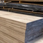 Large stack of finished finger-jointed ash furniture boards stored in a warehouse.