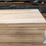 Front view of a stack of ash boards showing the smooth sanded surface of the top panel.