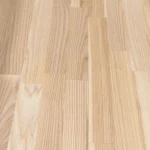 Angled close-up of the natural wood grain and joints of a finger-jointed ash panel.