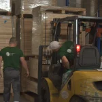 Forklift and workers moving veneer pallets at the WoodWay Expert warehouse