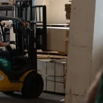 Forklift moving a pallet of FC plywood sheets in the warehouse