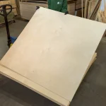 Worker holding a sheet of FC birch plywood 1525x1525 mm