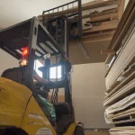 Forklift moving veneered plywood in the warehouse