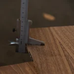 Measuring 10 mm thickness of American walnut veneered plywood with a caliper.