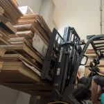 Погрузчик перемещает паллеты со шпонированной фанерой на складе WoodWay Expert.