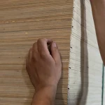 Рука лежить на торці стопки фанери з тополі завтовшки 8 мм.