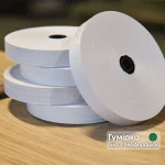 White perforated gummed tape rolls for Kuper veneer splicing on a wooden table