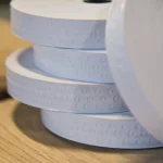 Close-up of perforated edges of white gummed tape for veneer