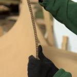 Master in gloves bending flexible MDF in the warehouse