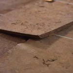 Close-up of the edge of Amboyna burl veneer sheet showing 0.6 mm thickness