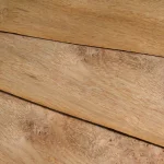 Sheets of natural oak burl veneer stacked on top of each other.