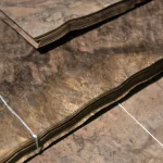 Edge of American walnut burl veneer bundle showing 0.6 mm thickness