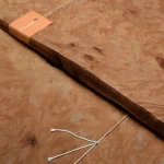 Edge of Madrone burl veneer bundle showing sheet thickness of 0.6 mm