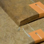Close-up of Myrtle burl veneer sheets stack showing 0.6 mm thickness.