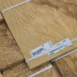 Texture of olive ash burl veneer sheet with package marking.