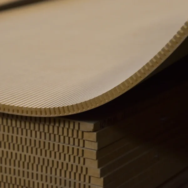 A bent sheet of flexible MDF 10 mm over a stack of boards in the warehouse