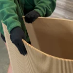 The process of bending a large flexible MDF board wearing gloves