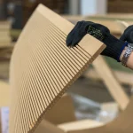 Person in gloves holding a flexible MDF sheet while bending