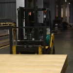 Forklift moving a stack of oak veneered MDF boards in the warehouse