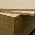 Edges of stacked oak veneered MDF boards showing 26 mm thickness.